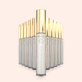Multiple skincare bottles  of Brow Daddy VANILÁMI Brow Styling Aftercare with gold caps on a light pink background