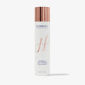 Skincare bottle with rose gold cap and white label on a light gray background